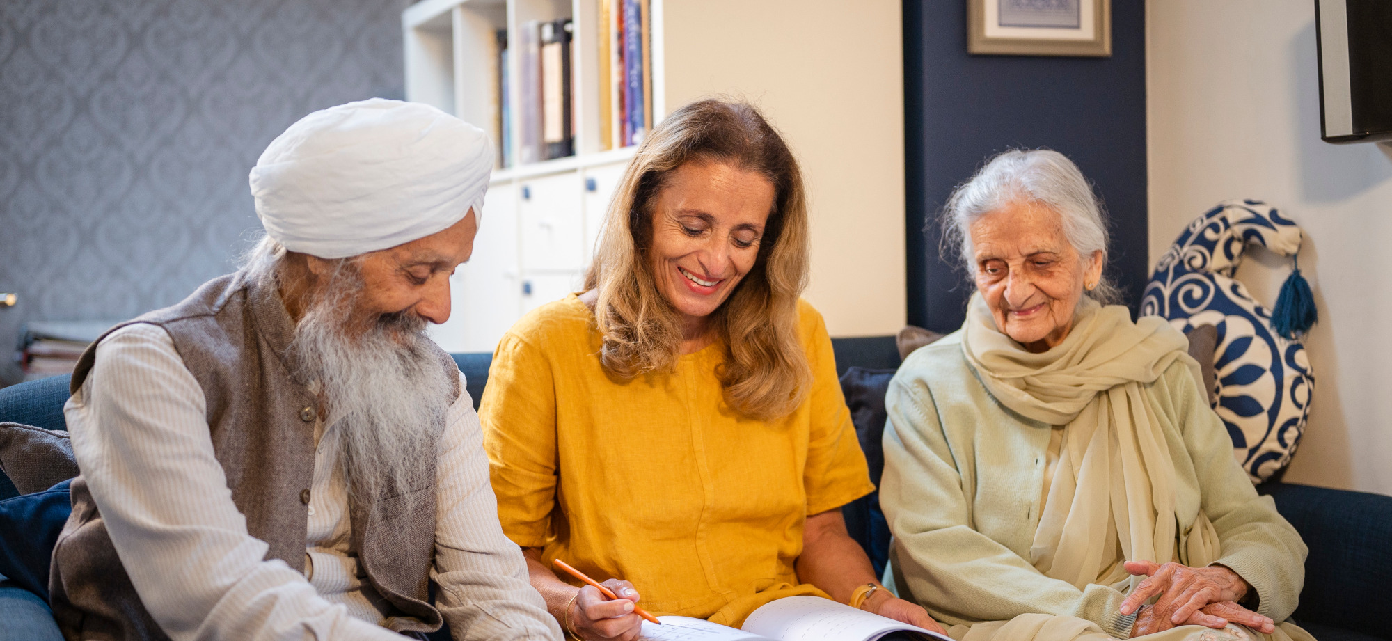 A photo of an elderly couple being guided through making meal choices by a carer