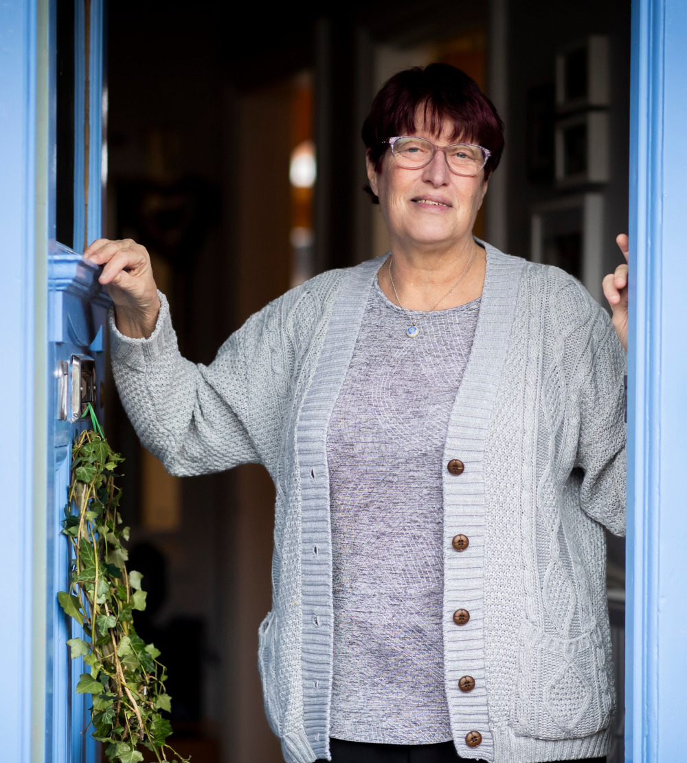 A photograph of a woman who's opened her door