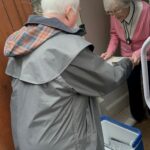 A CAMMS Meals on Wheels Ltd team member delivering a meal to a client at home