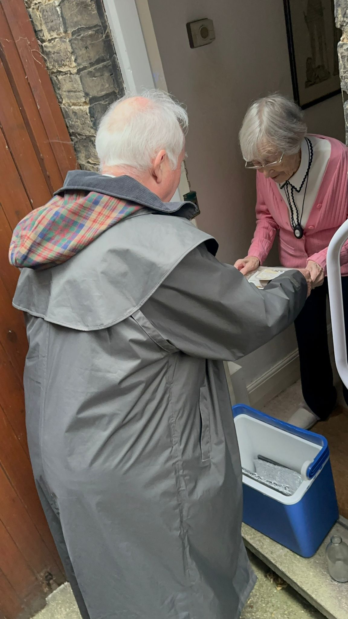 A CAMMS Meals on Wheels Ltd team member delivering a meal to a client at home
